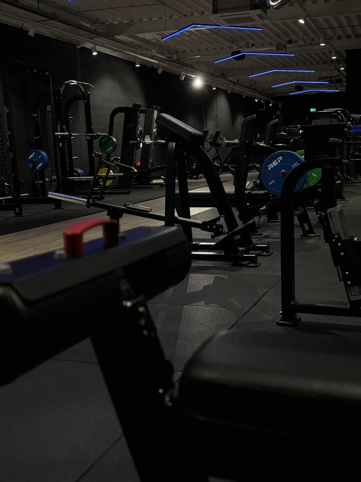 Vrije gewichtenzone met squat racks en halterschijven bij Route27 Schelle